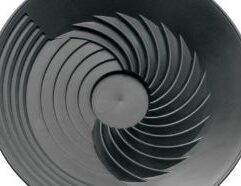 TurboPan Gold Prospecting Tools 10″ Black Plastic Gold Pan for Sluice Panning This black Gold Pan is the right piece of prospecting equipment that gets all the gold easily and quickly. The TurboPan gold pan is a prospecting tool and mining tool for the prospector and artisan miner involved in small scale mining. Whether you’re a hobbyist out looking for a run or a crevice filled with gold, or gold panning for a living in a developing country, TurboPan is the right piece of prospecting equipment that gets all the gold easily and quickly. TurboPan eliminates the problem of compaction that happens in the traditional “Klondike” pan because it is basically a circular sluice. TurboPan doesn’t require running water like a sluice, it simply maximizes the effects of gravity. Its shallow depth means it can be used in puddles and troughs. Do yourself a favor. Upgrade to a TurboPan, and make your gold panning as successful as it can be. It may be the best investment in your panning you will ever make. The TurboPan gold pan gets the gold and heavy minerals to the bottom of the pan and into a central trap quickly because the pan is shallow. The TurboPan is only around 5cm deep on the edges. It acts just like a “sluice in a pan” – trapping all the gold in its extensive riffle system. You’ll improve your panning prospects with TurboPan. It’s a better way to pan for gold! Instructions Place dirt into pan. It is best to only fill it 3/4 full, which is about 6kg. Ensure the concentric riffles are on the side away from you. These are the clean up riffles. Submerge pan underwater completely, holding the pan on each side. Rotate pan clockwise and anti-clockwise very quickly for about 5 seconds. This is to get the water to go right through the dirt and start the saturation process. Hold the pan with one hand. With your other hand, stir the dirt in the central collection trap, checking for compaction and clay where the water has not fully penetrated. Stir the dirt by hand until you’re satisfied complete saturation has occurred. Move the pan in an anti-clockwise motion so that the load moves inside the pan anti-clockwise. The purpose of this is to get the dirt moving over the spiral riffles so that the gold will work its way into the grooves.It is important to go anti-clockwise so that the clays in suspension will not compact against the steep sides of the spiral riffles. An initial sharp movement helps to get the dirt moving. Swirl in an anti-clockwise direction for 25-30 seconds. Alternate between a centering swirl to get the “heavies” into the middle and the “lights” to the surface and outside, then an ejection swirl. It is normal for a little dirt to fly out of the pan at the edge. If a lot is going out, slow down your swirling rhythm so that only a small amount flies out with each swirl.Keep swirling until the amount of material left just covers the central trap. There are several techniques for using this pan – and scraping out the waste by hand is one of them – but this is not recommended for beginners. Shake the pan vigorously forwards and backwards and from side to side for 10 seconds, to get the gold down off the clean-up riffles, so all the gold is in the central trap. While shaking the pan from side to side, tilt the pan forward and allow dirt to run out of the front of the pan. Ensure clean-up riffles are at the front of the pan – away from you. After half the dirt has been ejected, centre the pan again, do a few more clockwise swirls and repeat steps 6 & 7. Work out your own careful clean up technique for reducing concentrate to gold only or mostly gold only. Pick out nuggets. Pick up large flecks of gold by firstly drying your hand, wetting the end of your finger with saliva, and picking them up with the end of your finger. Place them into a jar, vial, etc. It’s best to suck up gold fines and dust with a plastic squirter bottle that has a tube from the mouth of the bottle to the bottom of the bottle.