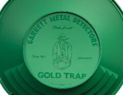 GARRETT 14" GOLD TRAP Gold Pan Expands the pan’s floor size by 33%, as compared to conventional 14" gold pans. Maintains the long panning surface and optimum angle necessary for effective panning. Patent-pending design. Allows gold to be driven down more efficiently to the large floor space. Larger pan volume allows more material to be processed per pan. Includes Garrett’s renowned riffles for trapping gold. An Offset, Acentric Design Delivers Improved Performance! Garrett’s world famous Gravity Trap gold pan series has led the industry for 30 years. Garrett’s gold pans feature a 90° riffled design that ensures safe, sure, rapid gold recovery in wet or dry conditions. All Garrett pans are lightweight, green for enhanced gold nugget visibility, and virtually indestructible. Tested and proven worldwide by Charles Garrett, Roy Lagal and tens of thousands of prospectors, Garrett’s gold pans are a must for every recreational and electronic gold seeker. Don't Lose It! Garrett's exclusive 90 degree riffled design prevents gold from sloshing out of the pan.
